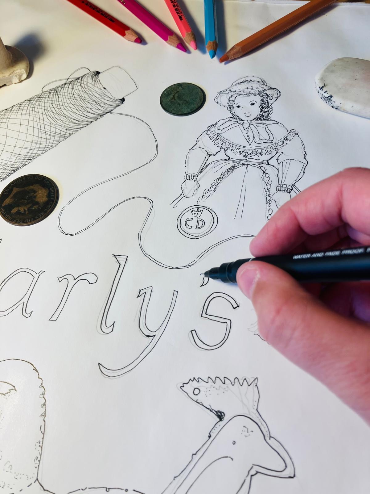 A hand is drawing a line drawing of spool of cotton, a doll and the Earlys sign